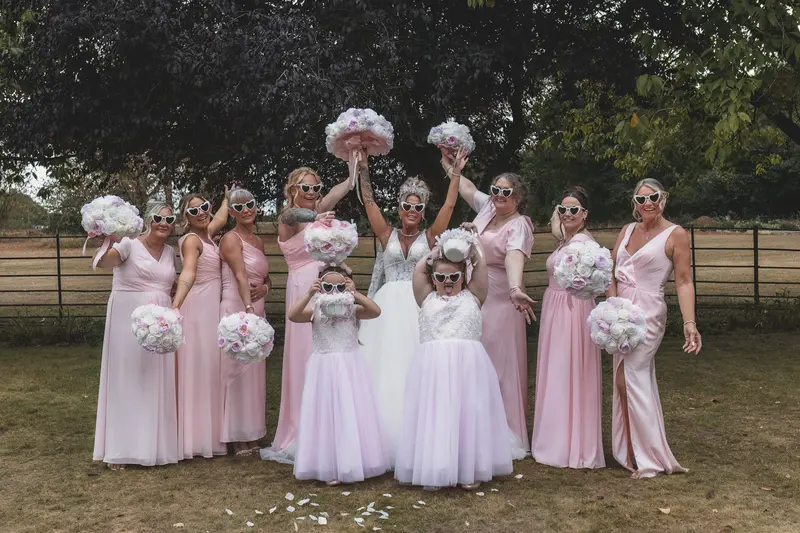 Stylish bridesmaids group photo with heart sunglasses and pink dresses