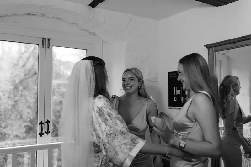 Emotional bridal morning moment with bridesmaids laughing during wedding preparations
