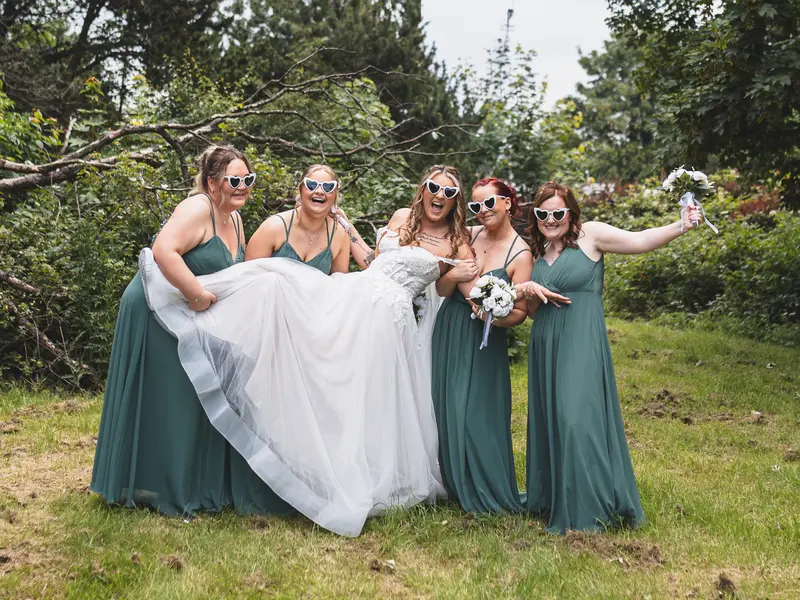 Bride laughing with bridesmaids during fun candid wedding photography session
