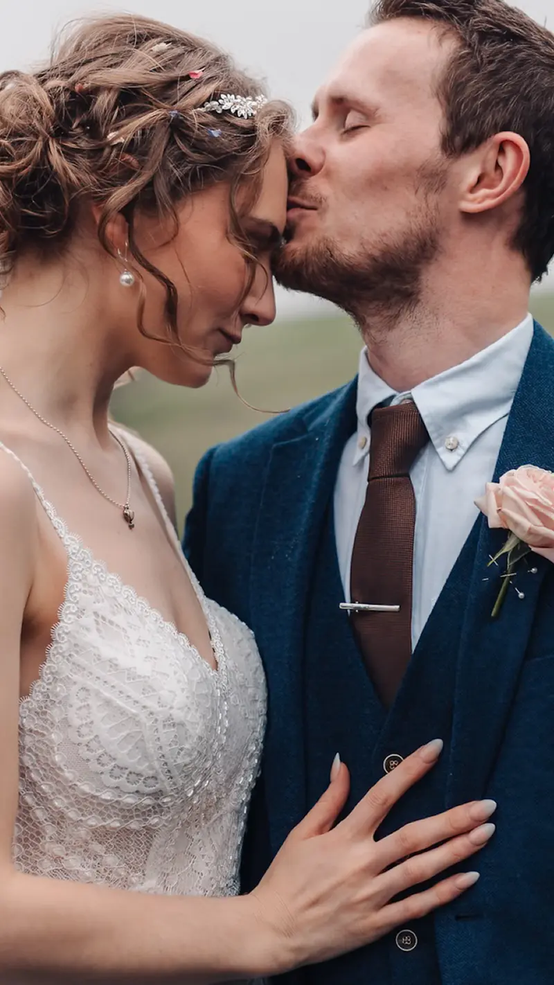 Emotional close up wedding portrait with forehead kiss and intimate connection