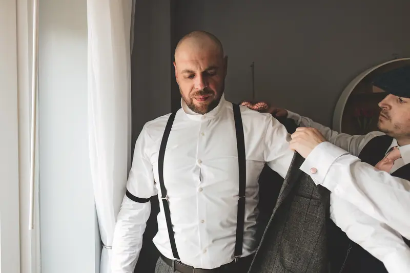 Groom having his braces adjusted during natural groom preparation photography