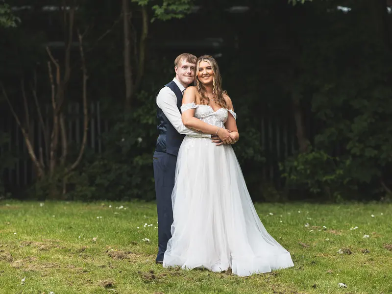 Bride and groom embracing during relaxed outdoor wedding photography