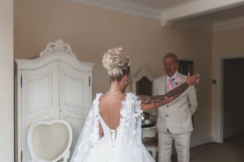 Emotional father first look with bride in elegant wedding morning preparation room