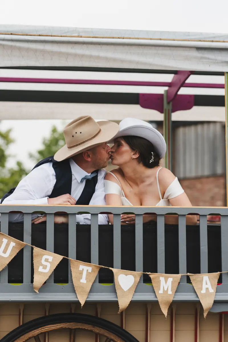 Romantic wedding kiss photo on rustic countryside wagon ride