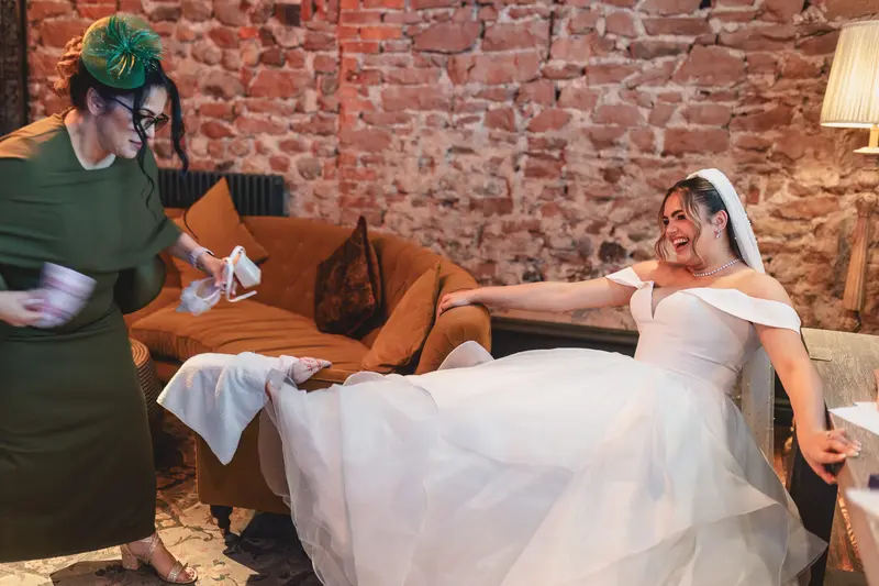Bride laughing with her mother during relaxed wedding morning preparations