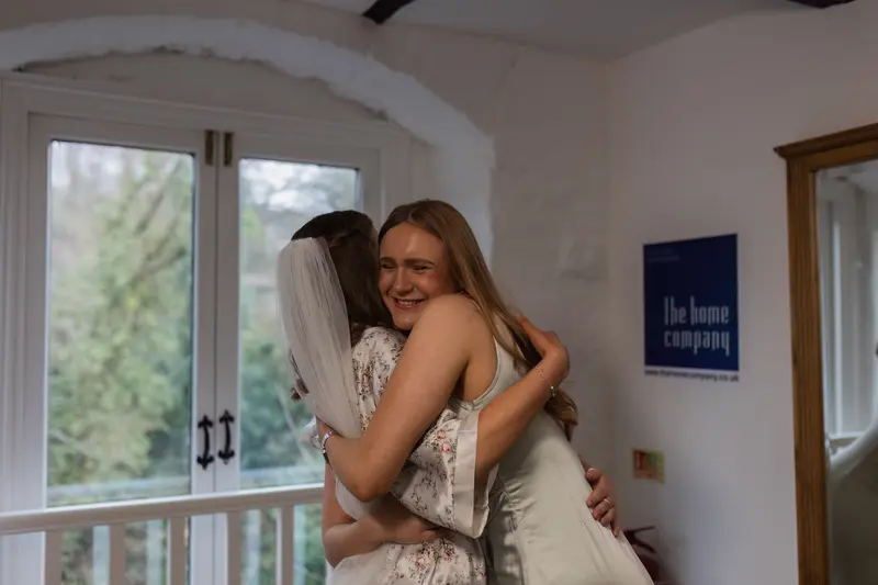 Emotional bridal hug with bridesmaid during documentary wedding morning in Yorkshire