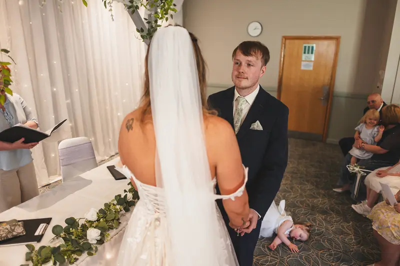 Groom smiling at his bride during the wedding ceremony