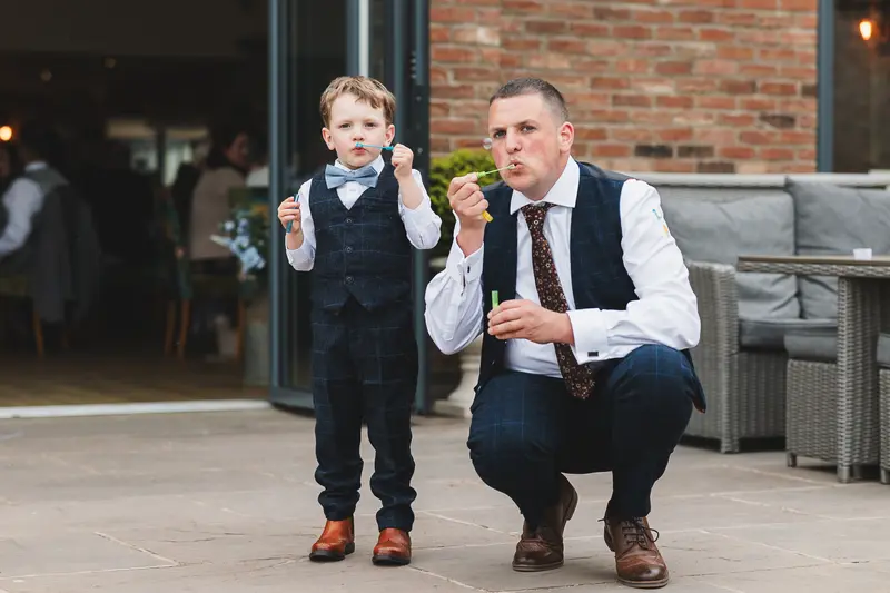 Father and son candid wedding bubbles moment documentary style