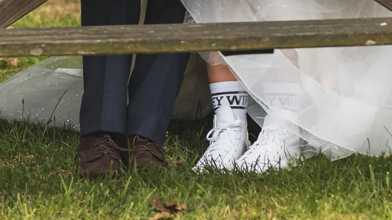 Creative close up of wedding shoes beneath the bride's dress