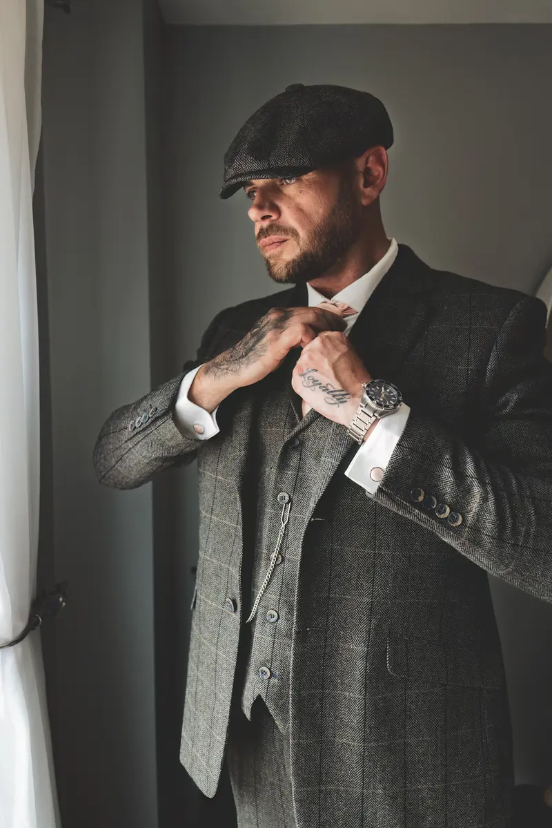 Stylish groom portrait by the window during wedding morning preparations