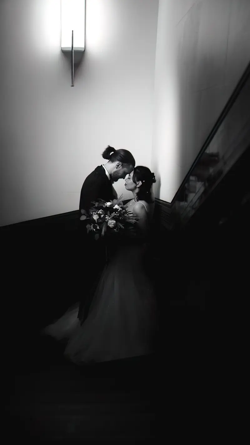Emotional black and white wedding portrait on staircase, artistic documentary wedding photographer