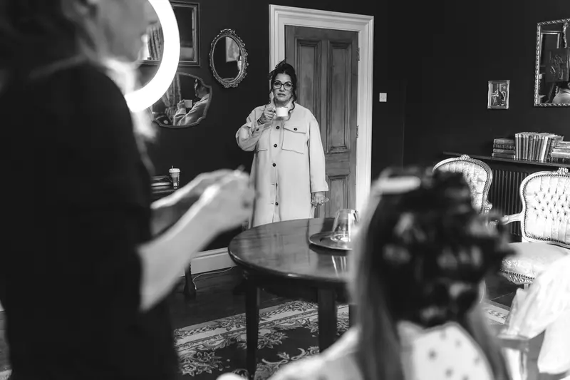 Bride having her makeup finished during relaxed wedding morning preparations