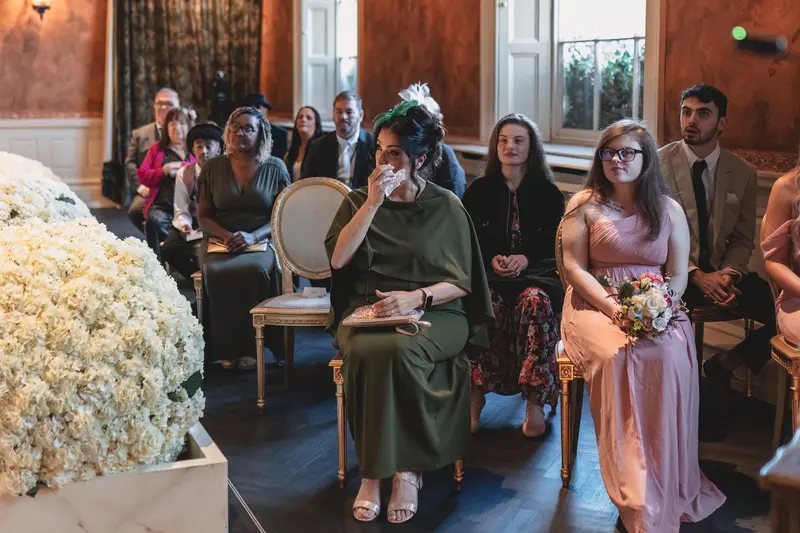 Emotional wedding guest reactions during intimate indoor ceremony