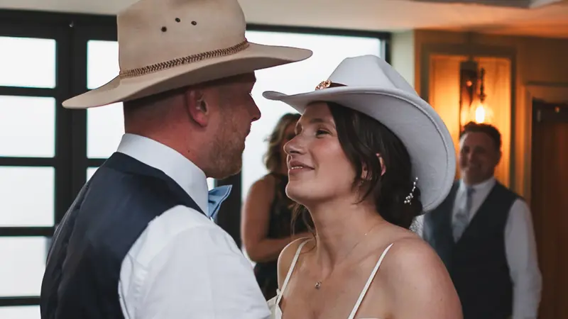 Fun cowboy hat wedding dance floor moment during evening reception