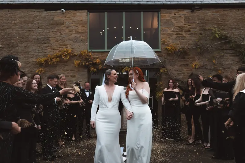 Rainy wedding exit with confetti at rustic Yorkshire wedding venue