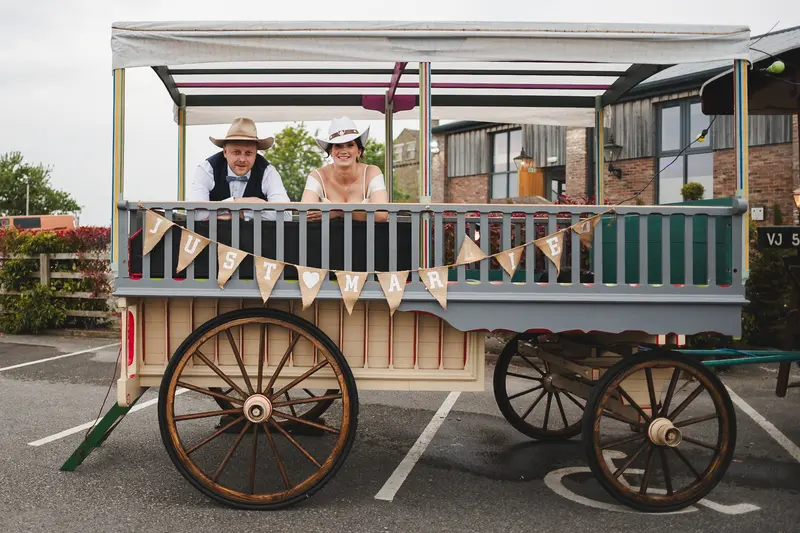 Fun wedding portrait on vintage fairground wagon in Yorkshire