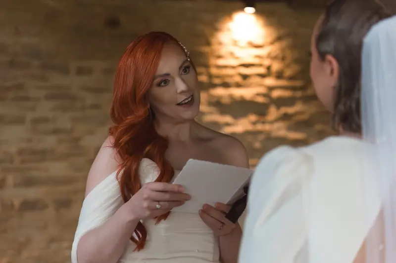 Bride reading emotional wedding vows during intimate lesbian ceremony in Yorkshire