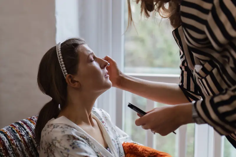 Natural bridal makeup preparation photo by window at Yorkshire documentary wedding
