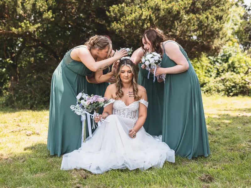 Emotional bridesmaids hugging the bride before the wedding ceremony