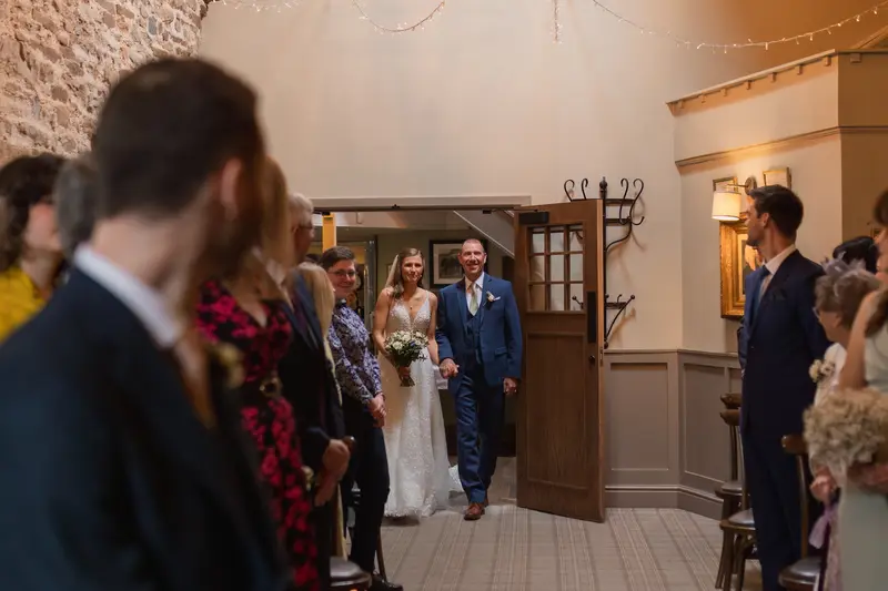 Emotional bride walking down the aisle with father during Yorkshire wedding ceremony