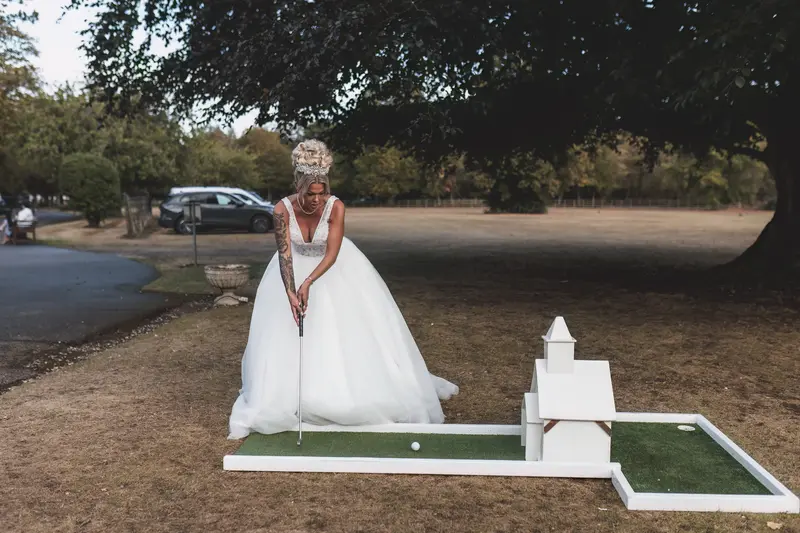 Bride playing mini golf during fun wedding reception moments