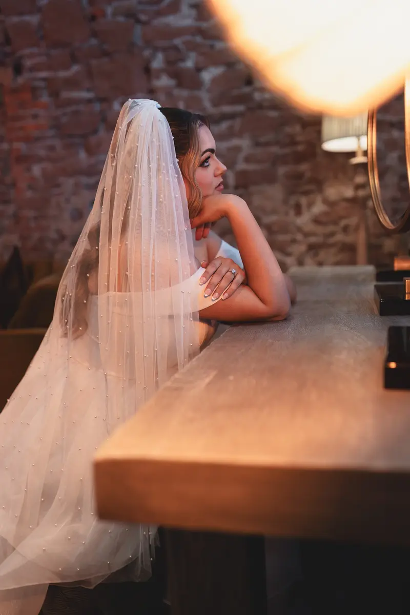 Bride relaxing at the bridal suite vanity before the ceremony, captured in elegant documentary wedding photography