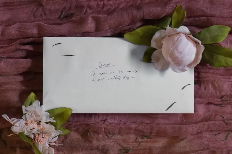 Documentary wedding letter flat lay with flowers during Yorkshire bridal preparations