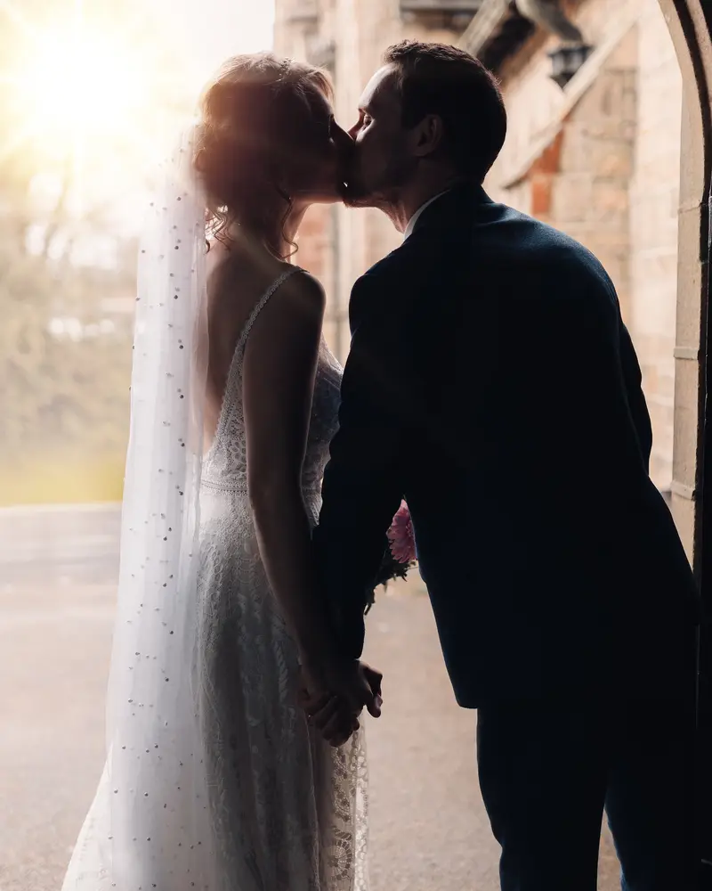 Romantic couple portrait under church archway captured by Yorkshire wedding photographer