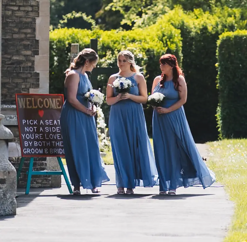 Blue bridesmaid dresses walking at Yorkshire church wedding