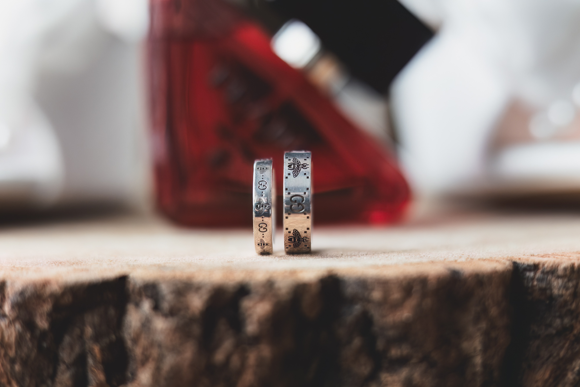 Close up of engraved wedding rings with perfume bottle during bridal preparations at a UK wedding